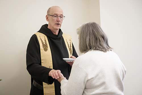A photo of a monk giving communion.